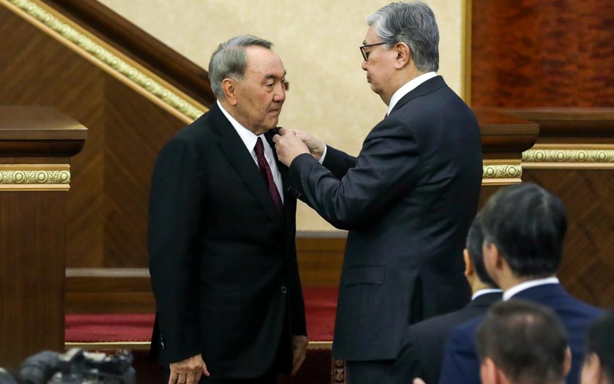 Kazakhstan's new president Kassym-Jomart Tokayev pins a medal on Nursultan Nazarbayev, who will remain head of the security council and ruling party, on Tuesday - TASS / Barcroft Media