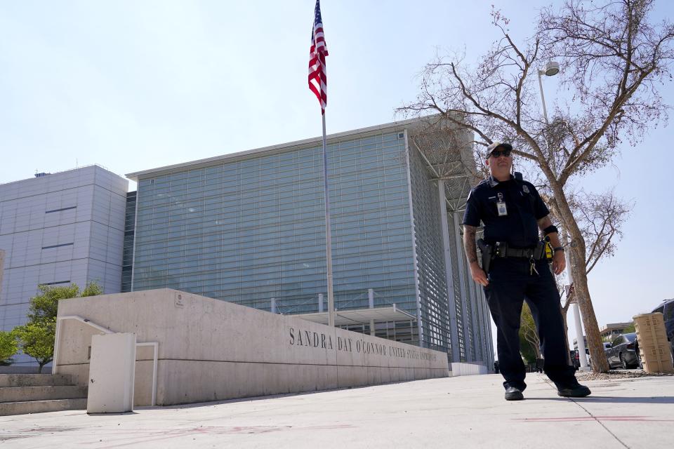 A Phoenix Police officer stands in front of the Sandra Day O'Connor U.S. Courthouse in Phoenix, on Tuesday, Sept. 15, 2020. A drive-by shooting wounded a federal court security officer Tuesday outside the courthouse in downtown Phoenix, authorities said. The officer was taken to a hospital and is expected to recover, according to city police and the FBI, which is investigating. (AP Photo/Ross D. Franklin)