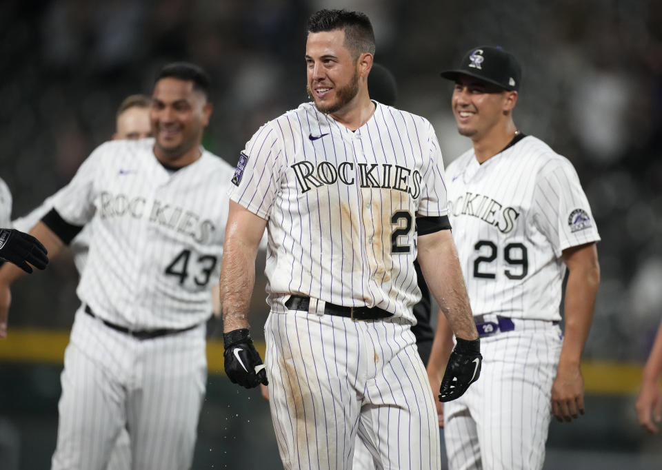 Colorado Rockies' C.J. Cron, front, smiles after driving in the winning run against the Milwaukee Brewers in the 10th inning of a baseball game Friday, June 18, 2021, in Denver. The Rockies won 6-5. (AP Photo/David Zalubowski)