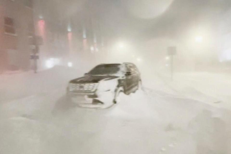 High winds and snow covers the streets and vehicles in Buffalo, N.Y. early Sunday, Dec. 25, 2022. The safest place to be in a storm is at home, experts say.