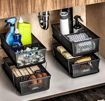 the baskets under a sink cabinet filled with cleaning supplies