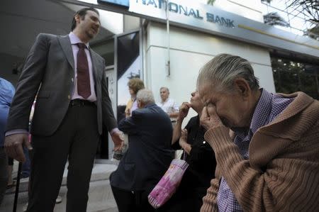 A bank manager explains the situation to pensioners waiting outside a branch of the National Bank of Greece hoping to get their pensions, in Thessaloniki, Greece June 29, 2015. REUTERS/Alexandros Avramidis