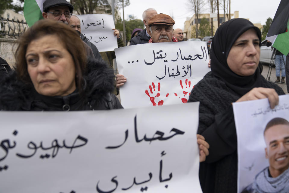 Palestinian activists carry posters, one reads "the siege is killing the children," while protesting in front of the Egyptian embassy, in the West Bank city of Ramallah, Sunday, Feb. 18, 2024. Tens of activists carried posters and chanted slogans protesting the ongoing closure of the Rafah border crossing during the war between Israel and Hamas and accusing Egyptian authorities of "taking part in the Israeli siege of Gaza." (AP Photo/Nasser Nasser)