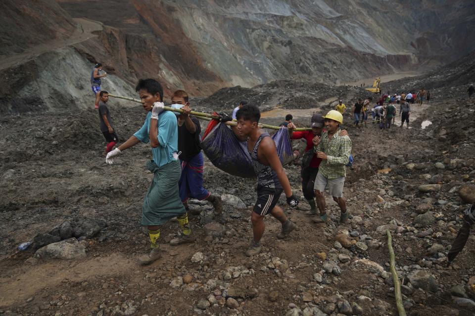 Rescue workers use poles to carry a body shrouded in blue and red plastic sheet Thursday, July 2, 2020, in Hpakant, Kachin State, Myanmar. At least 162 people were killed Thursday in a landslide at a jade mine in northern Myanmar, the worst in a series of deadly accidents at such sites in recent years that critics blame on the government's failure to take action against unsafe conditions. (AP Photo / Zaw Moe Htet)