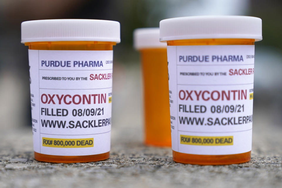 FILE - Fake pill bottles with messages about OxyContin maker Purdue Pharma are displayed during a protest outside the courthouse where the bankruptcy of the company is taking place in White Plains, N.Y., on Aug. 9, 2021. A three-judge panel of the 2nd U.S. Circuit Court of Appeals in New York on Tuesday, May 30 overturned a lower court’s 2021 ruling that found bankruptcy courts did not have the authority to protect members of the Sackler family who own the company and who have not filed for bankruptcy protection from lawsuits. (AP foto/Seth Wenig, File)