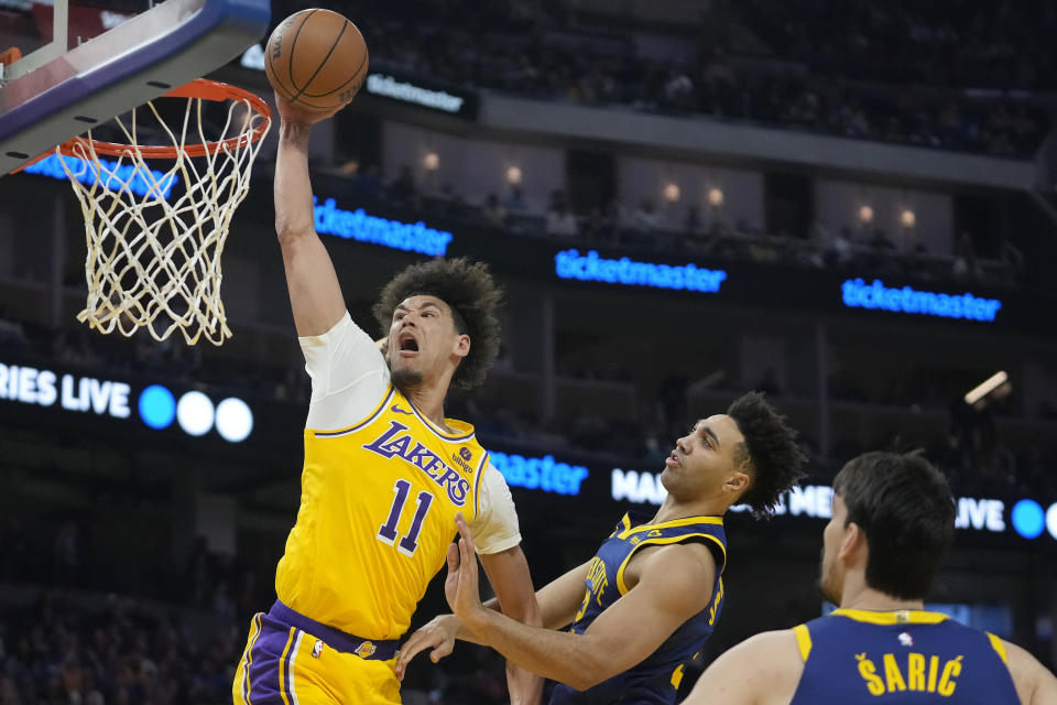 Los Angeles Lakers center Jaxson Hayes (11) dunks against Golden State Warriors forward Trayce Jackson-Davis, middle, and forward Dario Saric during the first half of an NBA basketball game in San Francisco, Thursday, Feb. 22, 2024. (AP Photo/Jeff Chiu)