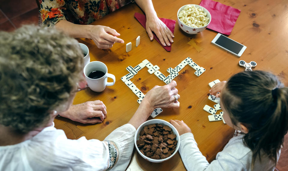 Top view of grandmother, daughter and granddaughter playing domino in the living room