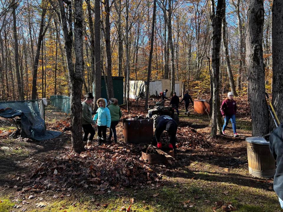 Volunteers from York work to clean up the yard and remove the mold-infested mobile home of Tom Barr, a Vietnam veteran and former Eliot police chief.