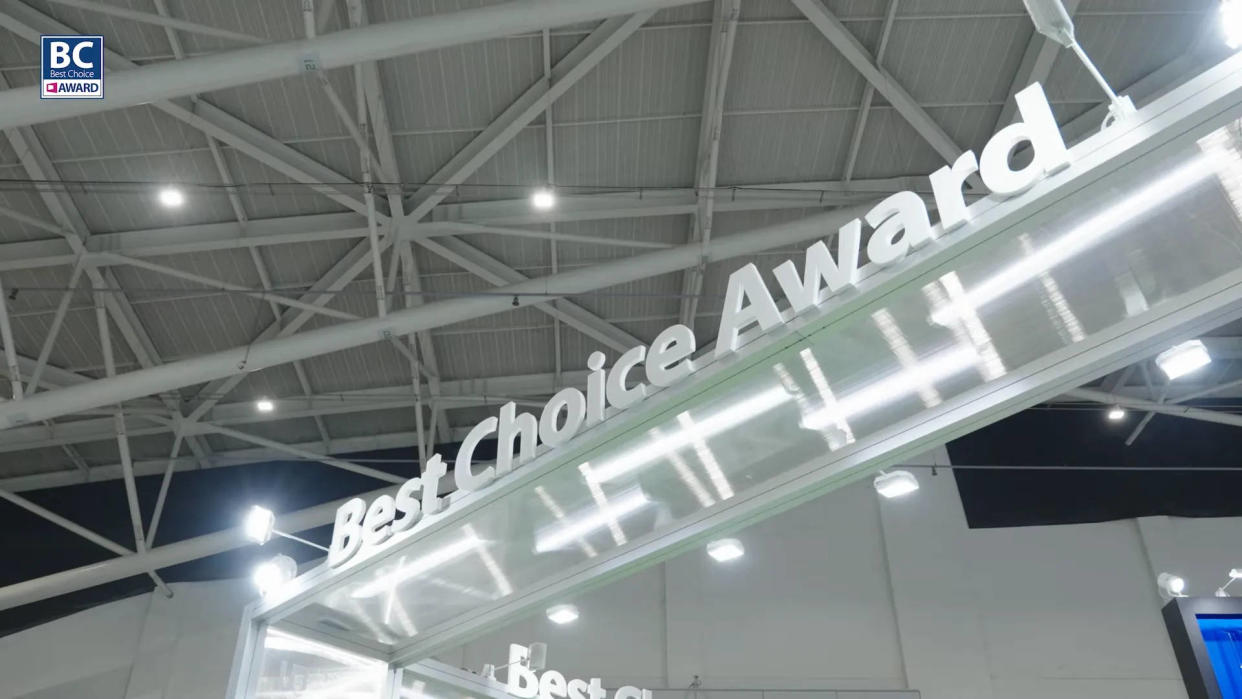  A photo of the Computex Best Choice Award stand, showing the title against a background of lights and sheet metal roofing, in Taiwan. 