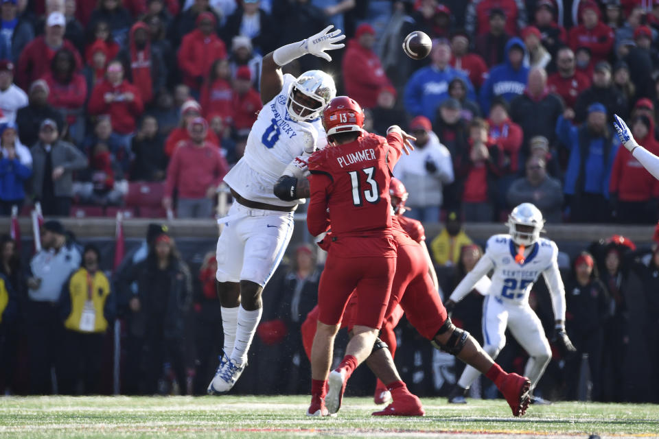 Kentucky defensive lineman Deone Walker (0) attempts to block the pass attempt by Louisville quarterback Jack Plummer (13) during the second half of an NCAA college football game in Louisville, Ky., Saturday, Nov. 25, 2023. Kentucky won 38-31. (AP Photo/Timothy D. Easley)