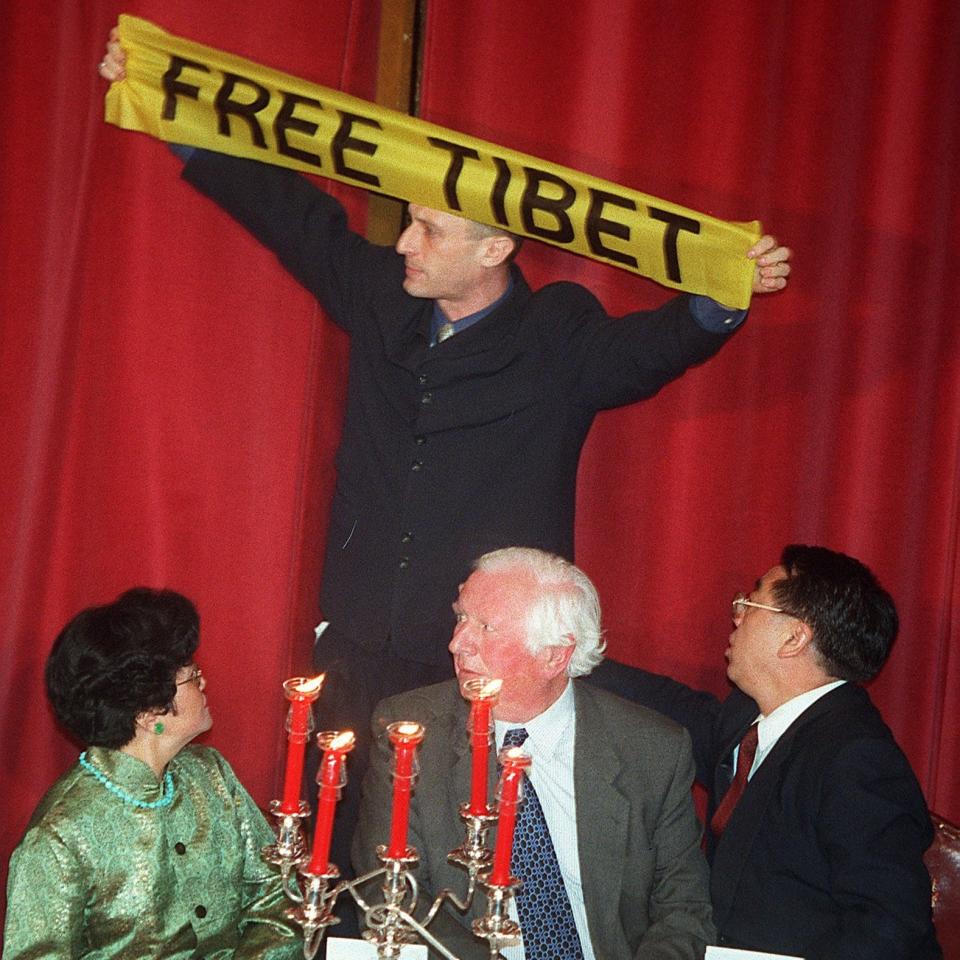 A Free Tibet protester holds up a banner inside the Guildhall in the City of London, April 1, 1998 as the Chinese Premier Zhu Rongji was about to speak - A