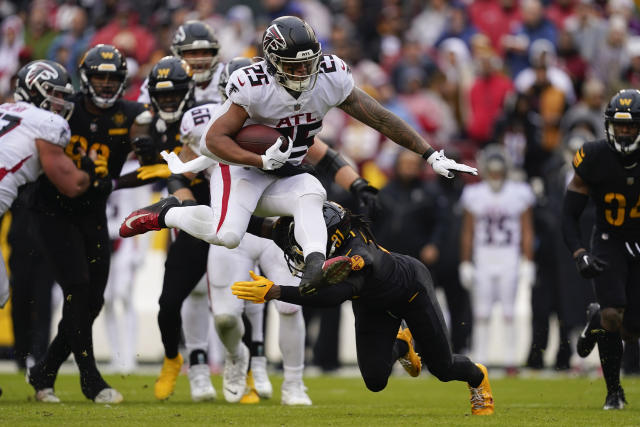 November 27, 2022: Atlanta Falcons running back Tyler Allgeier (25) leaps  over Washington Commanders safety Kamren Curl (31) during the NFL game  between the Atlanta Falcons and the Washington Commanders in Landover