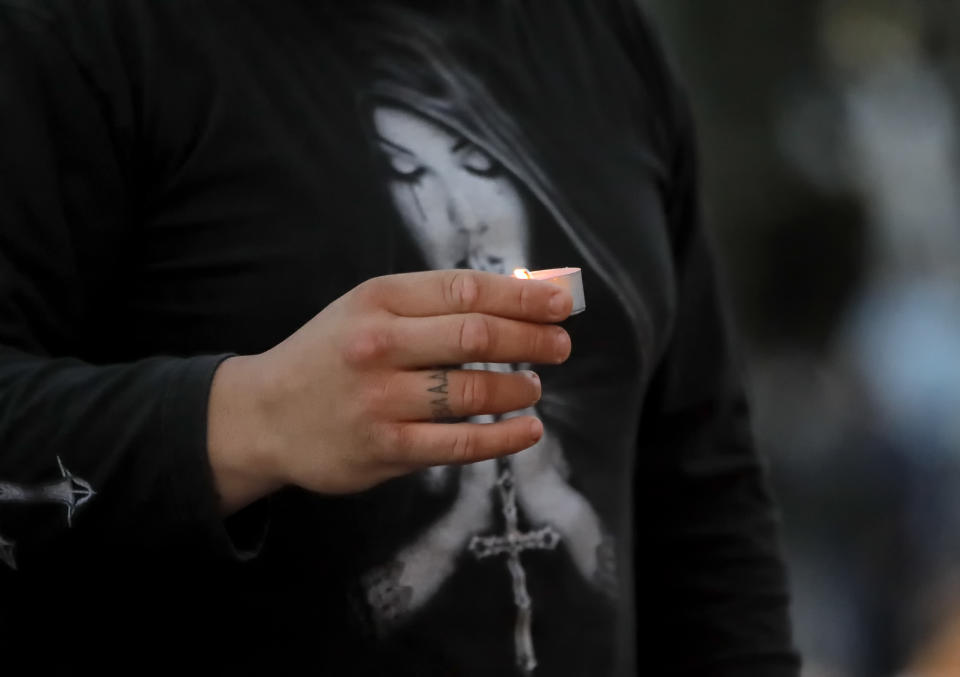 A man holds a candle during a vigil for Bulgarian journalist Viktoria Marinova, killed in the northern town of Ruse, is seen during a vigil in Sofia, Monday, Oct. 8, 2018. Bulgarian police are investigating the rape, beating and slaying of a female television reporter whose body was dumped near the Danube River after she reported on the possible misuse of European Union funds in Bulgaria. (AP Photo/Valentina Petrova)