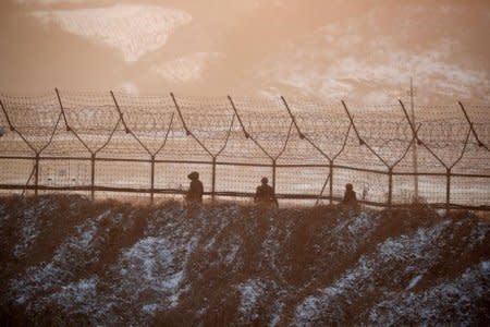 FILE PHOTO: South Korean soldiers patrol along a barbed-wire fence near the demilitarized zone separating the two Koreas, in Paju, South Korea, December 21, 2017.  REUTERS/Kim Hong-Ji