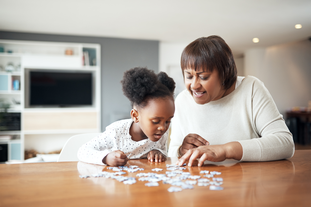 mother and daughter doing a puzzle at home