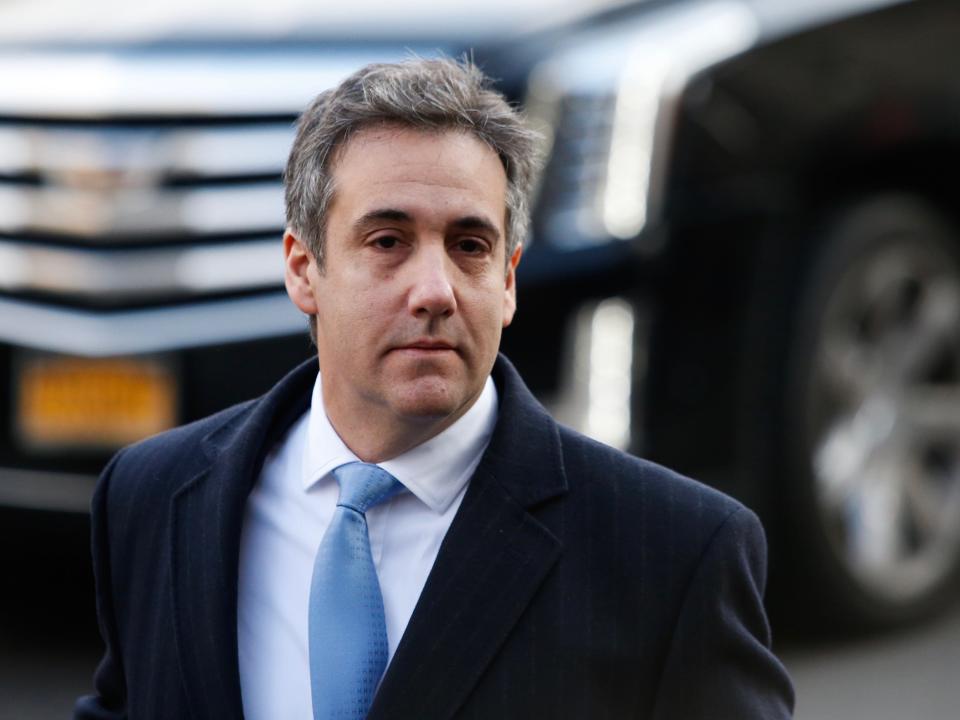 Michael Cohen in front of a Cadillac.