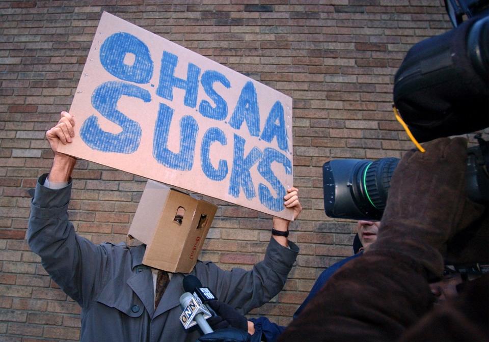 A disgruntled fan walks past St. Vincent-St. Mary High School on Jan. 31, 2003, following the news LeBron James had been ruled ineligible by the Ohio High School Athletic Association to play for the rest of the season for accepting free throwback jerseys.