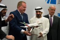 Boeing Commercial Airplanes president and CEO Stanley A. Deal, left, hands Sheikh Ahmed bin Saeed Al Maktoum, the chairman and CEO of the Dubai-based long-haul carrier Emirates, a model of a Boeing 787 Dreamliner at the Dubai Airshow in Dubai, United Arab Emirates, Wednesday, Nov. 20, 2019. Dubai's carrier Emirates announced Wednesday a firm order for 30 Boeing 787 Dreamliners in deal valued at $8.8 billion. (AP Photo/Jon Gambrell)