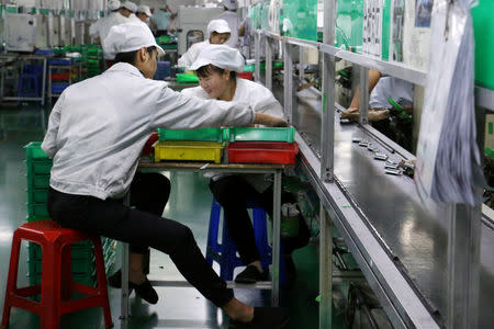 FILE PHOTO: Employees work at a production line of lithium ion batteries inside a factory in Dongguan, Guangdong province, China October 16, 2018. REUTERS/Joyce Zhou/File Photo