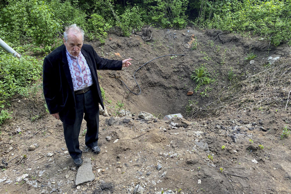 Volodymyr Krasnorutskiy, director of the science and technology shows a crater after airstrike at the territory of National Scientific Center "Kharkov Institute of Physics and Technology" in Kharkiv, Ukraine, Thursday, May 18, 2023. Institute staff say radiation could spread for 6 miles (10 kilometers), covering an area home to 640,000 people. (AP Photo/Oleksandr Brynza)