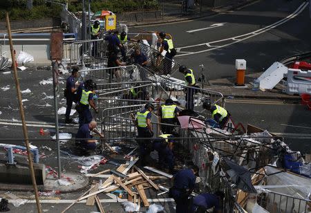 Police remove a barricade left by pro-democracy protesters on a main road leading to the financial Central district in Hong Kong October 14, 2014. REUTERS/Bobby Yip