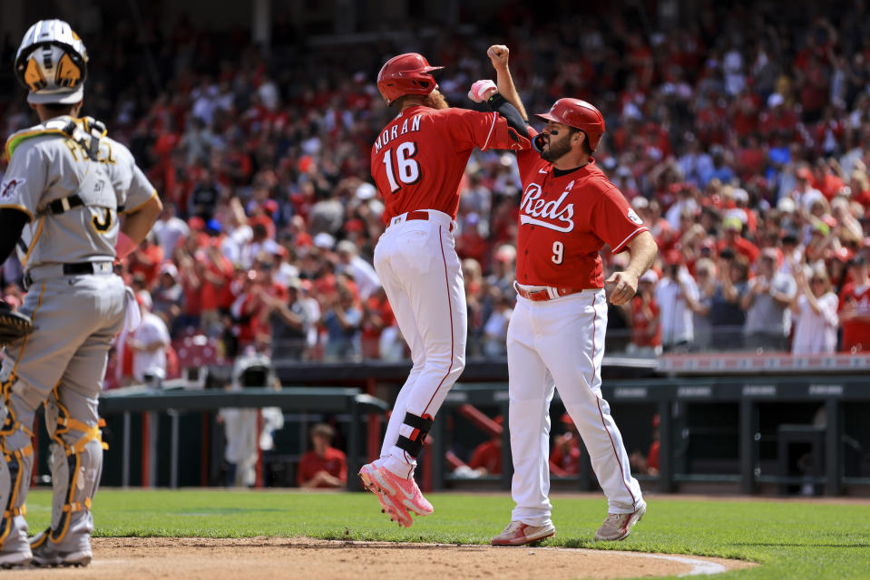 Cincinnati Reds' Colin Moran (16) celebrates with Mike Moustakas after hitting a grand slam during the sixth inning of a baseball game against the Pittsburgh Pirates in Cincinnati, Sunday, May 8, 2022. (AP Photo/Aaron Doster)