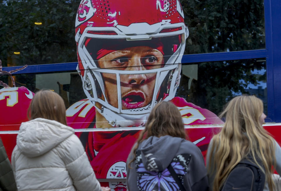 People look at a ship with the picture of Kansas City Chiefs quarterback Patrick Mahomes that docked in Frankfurt, Germany, Wednesday, Nov. 1, 2023. The Miami Dolphins are set to play the Kansas City Chiefs in an NFL game in Frankfurt on Sunday Nov. 5. The ship was chartered by the chiefs. (AP Photo/Michael Probst)