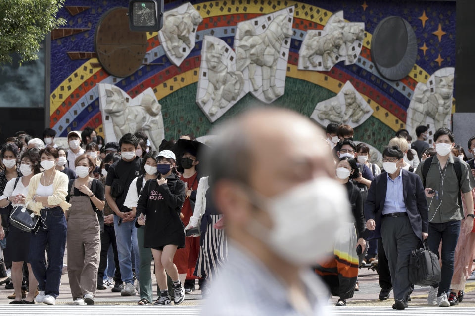 People wearing face masks walk along a pedestrian crossing at Shibuya district Thursday, Sept. 30, 2021, in Tokyo. Japan will lift its COVID-19 state of emergency in all of the regions at the end of September. Fumio Kishida, the man soon to become Japan’s next prime minister, says he believes raising incomes is the only way to get the world’s third-largest economy growing again. Top of Kishida’s to-do list is another big dose of government spending to help Japan recover from the COVID-19 shock. (AP Photo/Eugene Hoshiko)