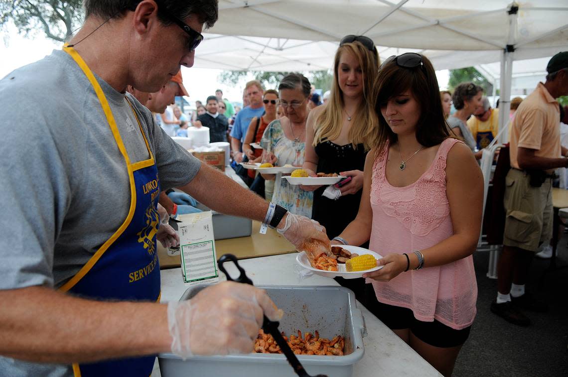 Doug Crowley with the Lowcountry Rotary Club serves shrimp to Maria Bartholf of Ridgeland during a previous Lowcountry Supper.