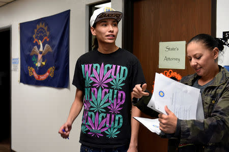 With his paper work in order, Terrell Elk, 18, waits with Desiree McArdel, a get-out-the vote worker, to get an absentee ballot form in the Sioux County Court House on the Standing Rock Reservation in Fort Yates, North Dakota, U.S. October 26, 2018. REUTERS/Dan Koeck
