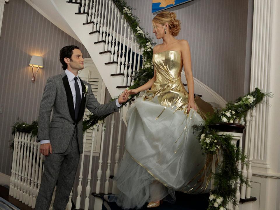 Dan and Serena look at each other on a staircase in their wedding attire.