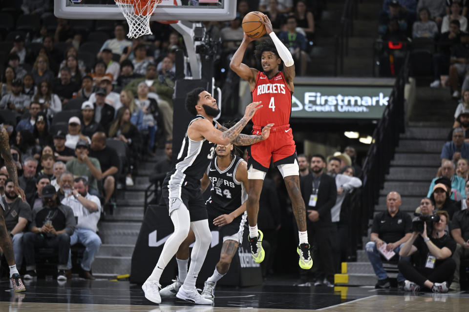 Houston Rockets' Jalen Green (4) looks to pass as San Antonio Spurs' Julian Champagnie and Devin Vassell (24) defend during the first half of an NBA basketball game Tuesday, March 12, 2024, in San Antonio. (AP Photo/Darren Abate)