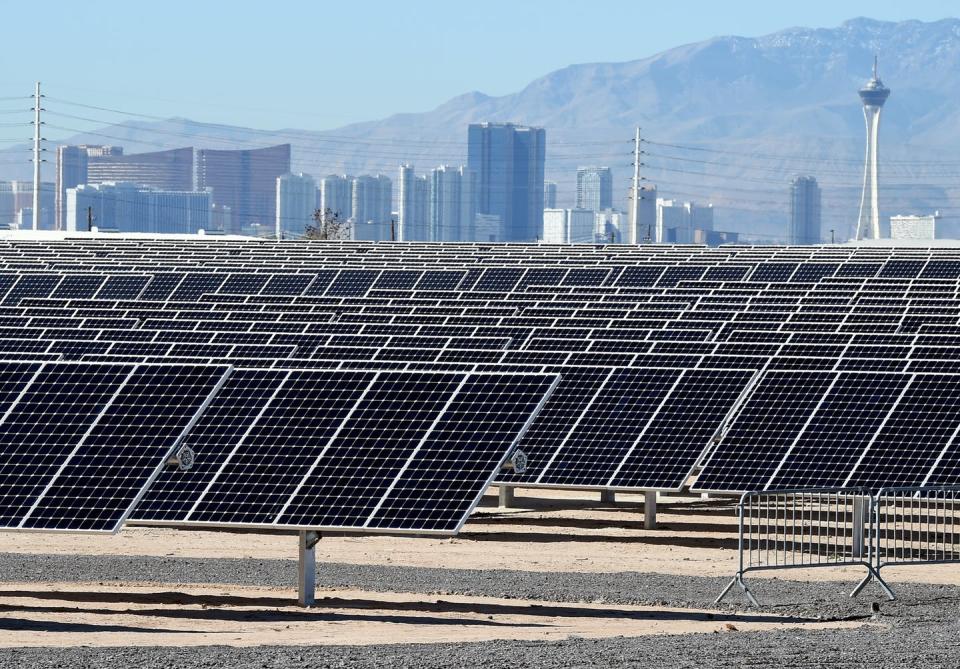 <span class="caption">Utility-scale solar is now cheaper than fossil fuels. This installation is at Nellis Air Force Base in Nevada.</span> <span class="attribution"><a class="link " href="https://www.gettyimages.com/detail/news-photo/the-las-vegas-strip-is-shown-behind-solar-panels-during-a-news-photo/510721582" rel="nofollow noopener" target="_blank" data-ylk="slk:Ethan Miller/Getty Images;elm:context_link;itc:0;sec:content-canvas">Ethan Miller/Getty Images</a></span>