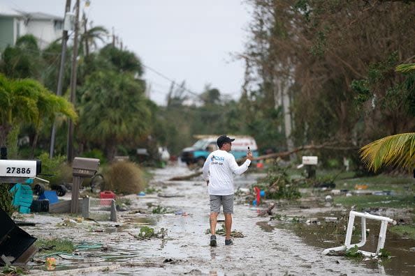 A man documents storm damage with his phone after Hurricane Ian on September 29, 2022, in Bonita Springs, Florida.