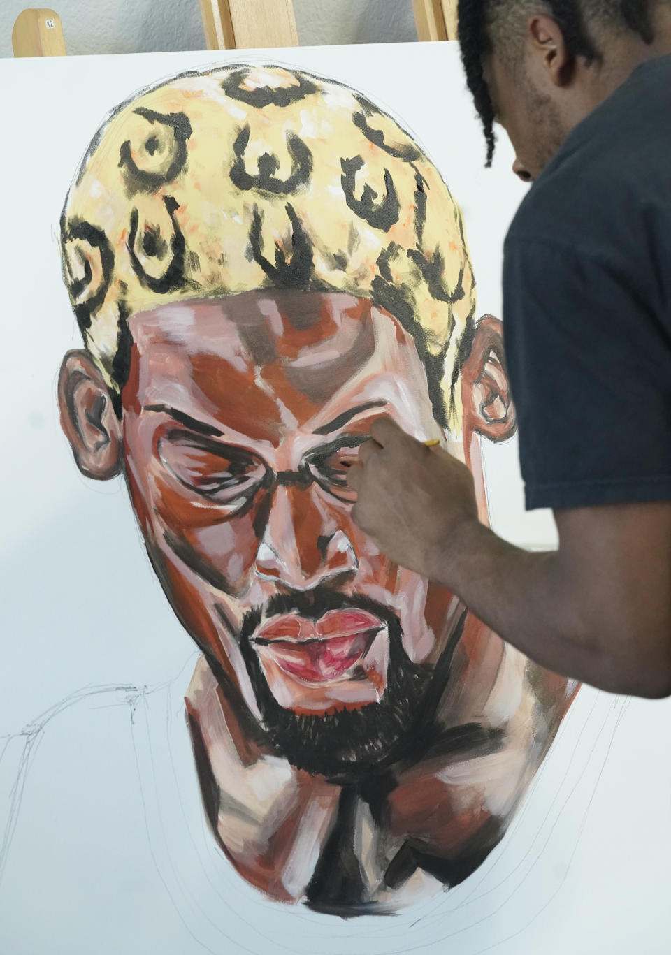 SMU defensive back RaSun Kazadi works on a painting at his apartment Wednesday, Aug. 11, 2021, in Dallas. The end of the NCAA ban on athletes being able to earn money for their fame and celebrity has led to some of them cashing in on their creative side. (AP Photo/LM Otero)