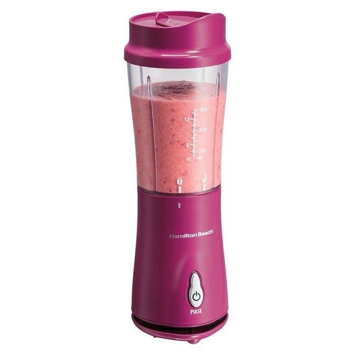 magenta single-serve blender making a smoothie