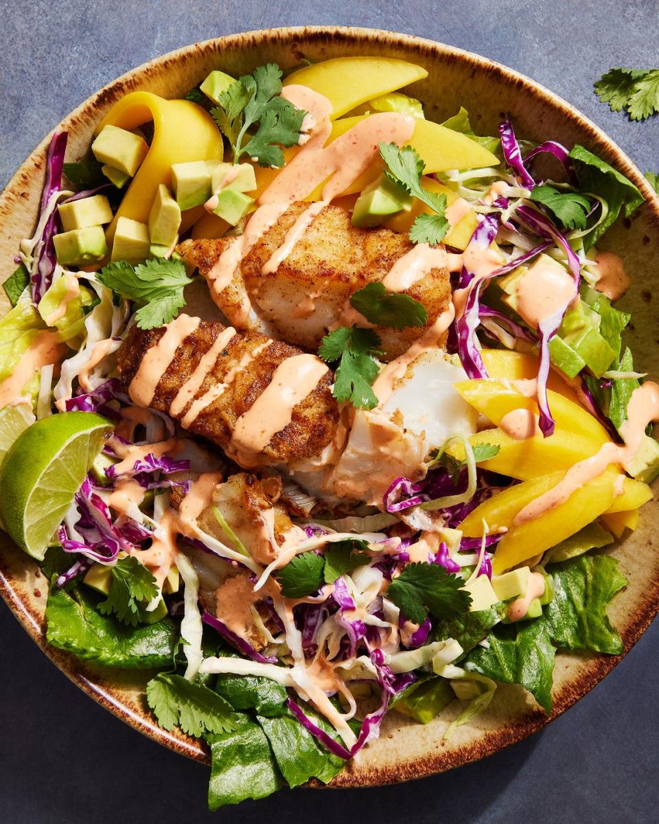 fish taco bowls with cabbage, mango, cilantro and a spicy cream drizzle