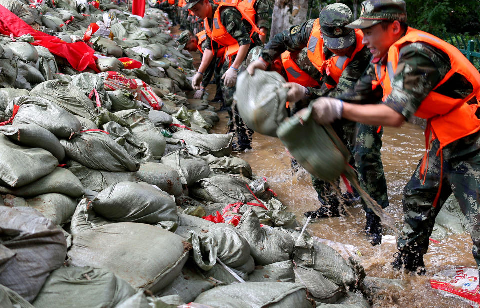 Soldiers carry sandbags