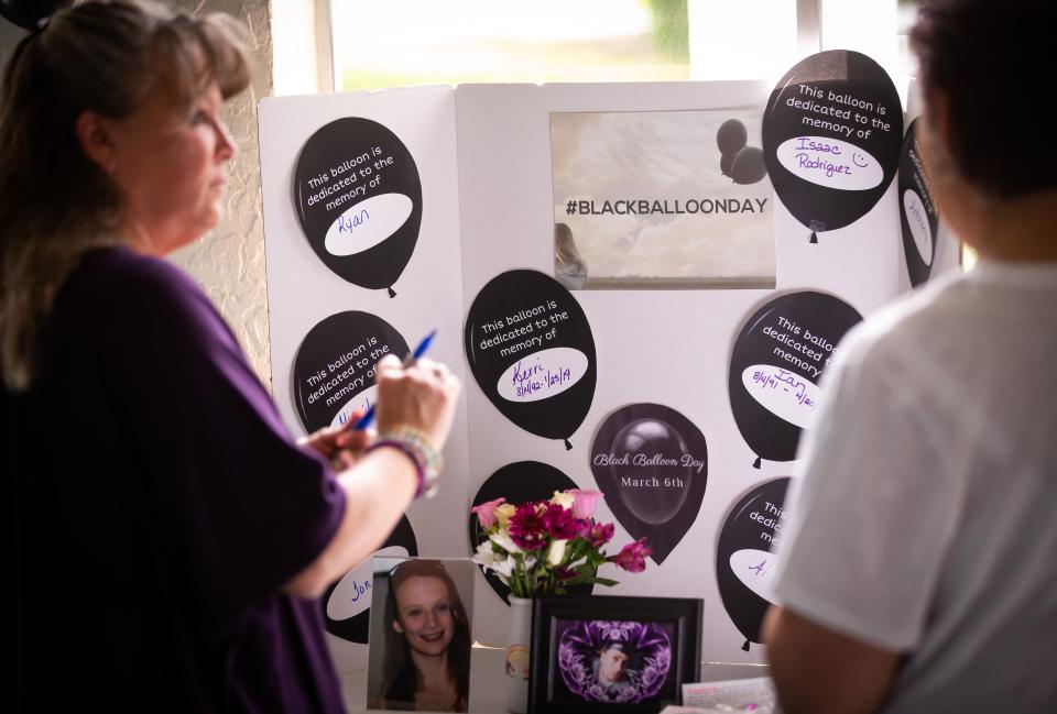 Lisa Bolton fills out a black balloon for her daughter, Kerri Fernley, who died from a drug overdose.