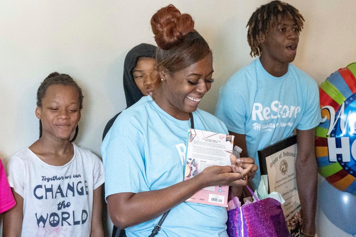 Val Morris takes a moment to enjoy the key to her family’s new house at the Habitat for Humanity Restore Build House Blessing, Tuesday June 28, 2022, in Lafayette.