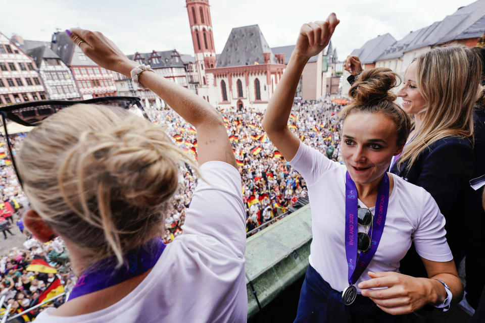 Laura Freigang, left, and Lina Magull, of the German women's team, celebrate on the balcony of the Roemer town hall, upon the team's return from the Women's Euro 2022 soccer, after losing to England in Sunday's final, in Frankfurt, Monday, Aug. 1, 2022. (Uwe Anspach /dpa via AP)