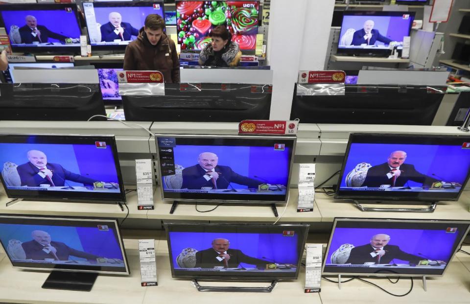 Belarus's President Alexander Lukashenko is seen on TV screens inside a shop, broadcast during a briefing in Minsk, Belarus, Friday, Feb. 3, 2017. In the televised broadcast on Friday, Lukashenko asked the country's interior minister to press charges against Russia's top food safety official, alleging charges of "damaging the state" because Russia stopped the import of Belarusian products due to quality issues and suspicions that Belarus resells EU-made dairy products that are banned in Russia. The Kremlin responded to the outburst, listing the loans and reduced taxes Russia gave to Belarus. (AP Photo/Sergei Grits)
