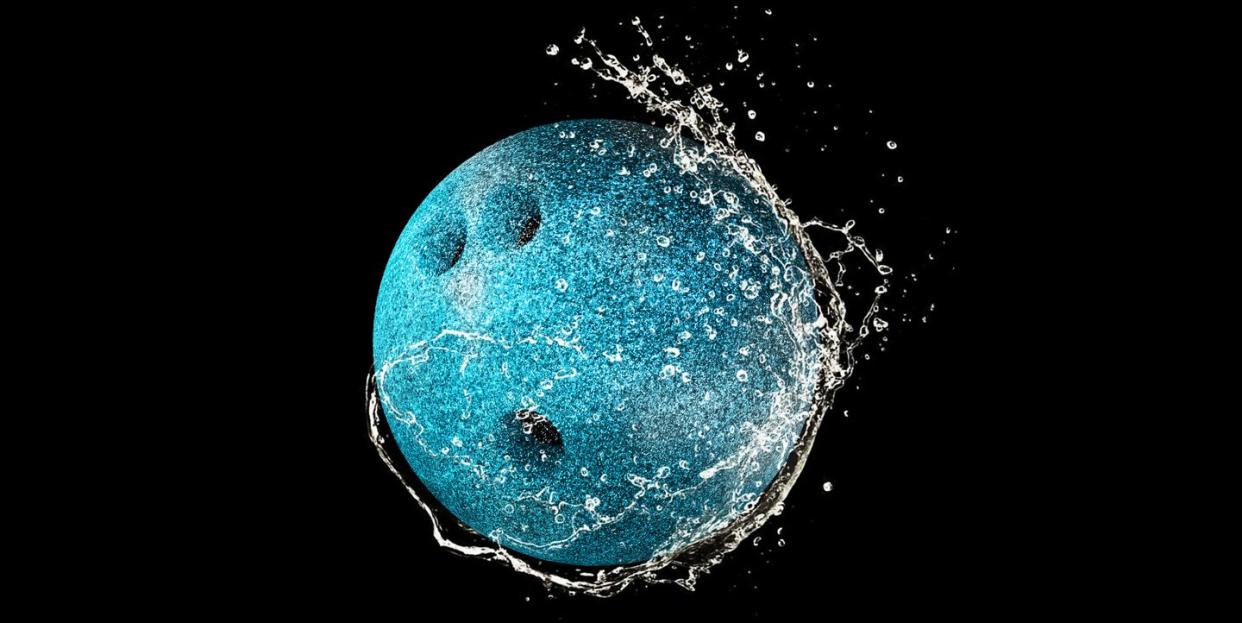 bowling ball in water drops and splashes isolated on black background