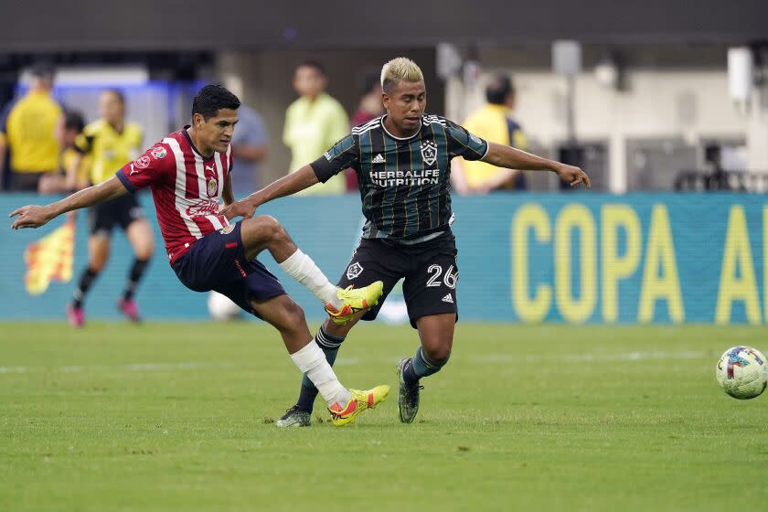 Chivas defender Jesus Sanchez, left, kicks the ball past Los Angeles Galaxy midfielder Efrain Alvarez during the first half of a Leagues Cup match Wednesday, Aug. 3, 2022, in Inglewood, Calif. (AP Photo/Mark J. Terrill)