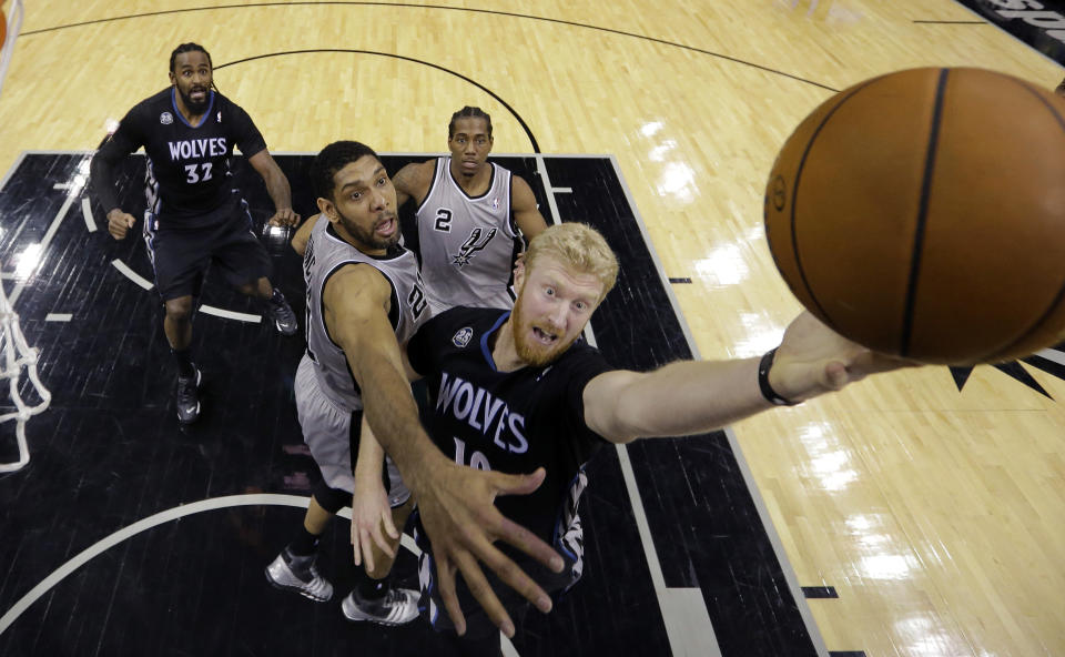 Minnesota Timberwolves' Chase Budinger, right, drives past San Antonio Spurs' Tim Duncan, center, to score during the first half of an NBA basketball game on Sunday, Jan. 12, 2014, in San Antonio. (AP Photo/Eric Gay)