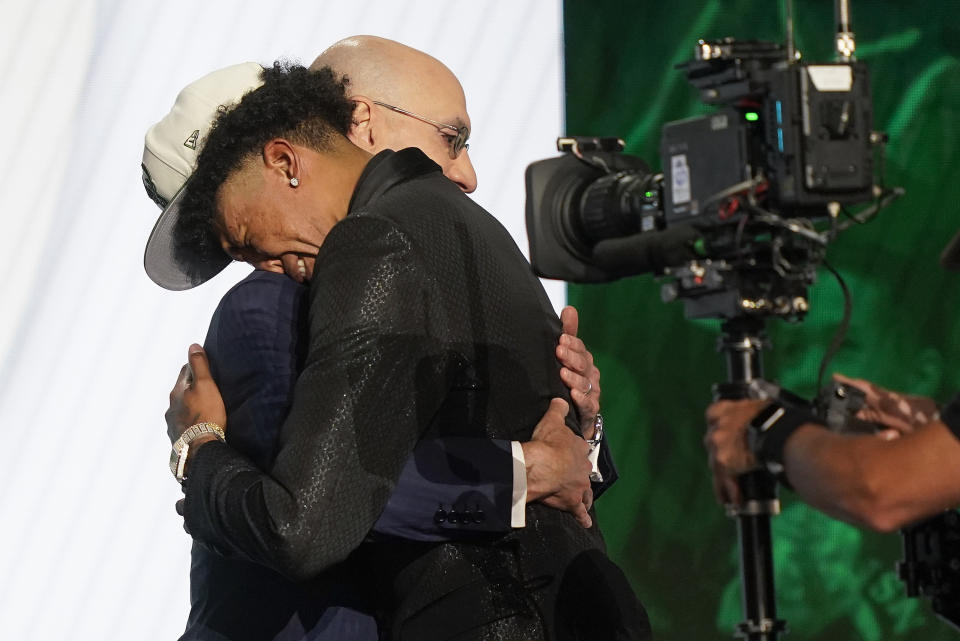 MarJon Beauchamp hugs NBA Commissioner Adam Silver after being selected 24th overall by the Milwaukee Bucks in the NBA basketball draft, Thursday, June 23, 2022, in New York. (AP Photo/John Minchillo)