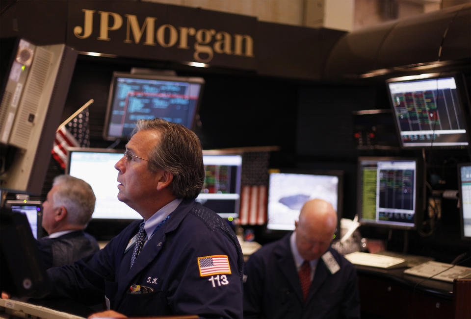 Traders work in the JP Morgan company stall on the floor of the New York Stock Exchange in New York July 15, 2010. JPMorgan Chase & Co posted higher-than-expected second-quarter earnings on Thursday after setting aside less money to cover bad loans, lifting investor hopes that bank results are returning to normal. REUTERS/Lucas Jackson (UNITED STATES - Tags: BUSINESS)