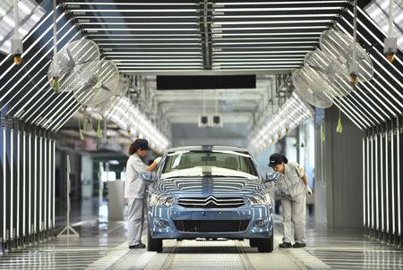 Employees work at the third factory of Dongfeng Peugeot Citroen Automobile company, after its inauguration ceremony, in Wuhan, in this July 2, 2013 file photo.
