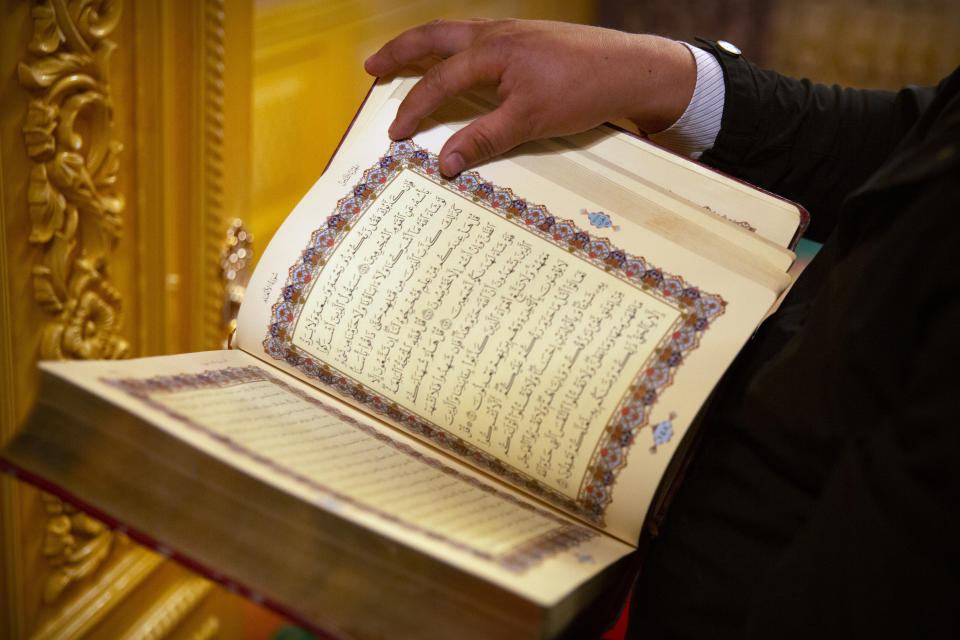 Tursunjan Mamat holds a copy of the Quran in the Arabic and Uyghur languages during a government organized visit for foreign journalists to his home in Aksu in western China's Xinjiang Uyghur Autonomous Region on April 20, 2021. Under the weight of official policies, the future of Islam appears precarious in Xinjiang, a remote region facing Central Asia in China's northwest corner. Outside observers say scores of mosques have been demolished, which Beijing denies, and locals say the number of worshippers is on the decline. (AP Photo/Mark Schiefelbein)