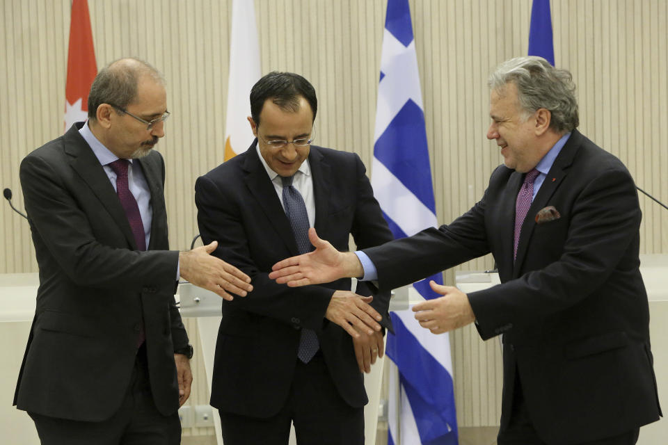 Cypriot foreign minister Nicos Christodoulides, center, shakes hands with Foreign minister of Jordan Ayman Safadi, left, and the Greek Alternate Minister of Foreign Affairs Georgios Katrougalos after their meeting at the presidential palace in Nicosia, Cyprus, Wednesday, Dec. 19, 2018. The three ministers are meeting in the Cypriot capital to explore ways of strengthening ties on fields as varied as education and entrepreneurship. (AP Photo/Petros Karadjias)